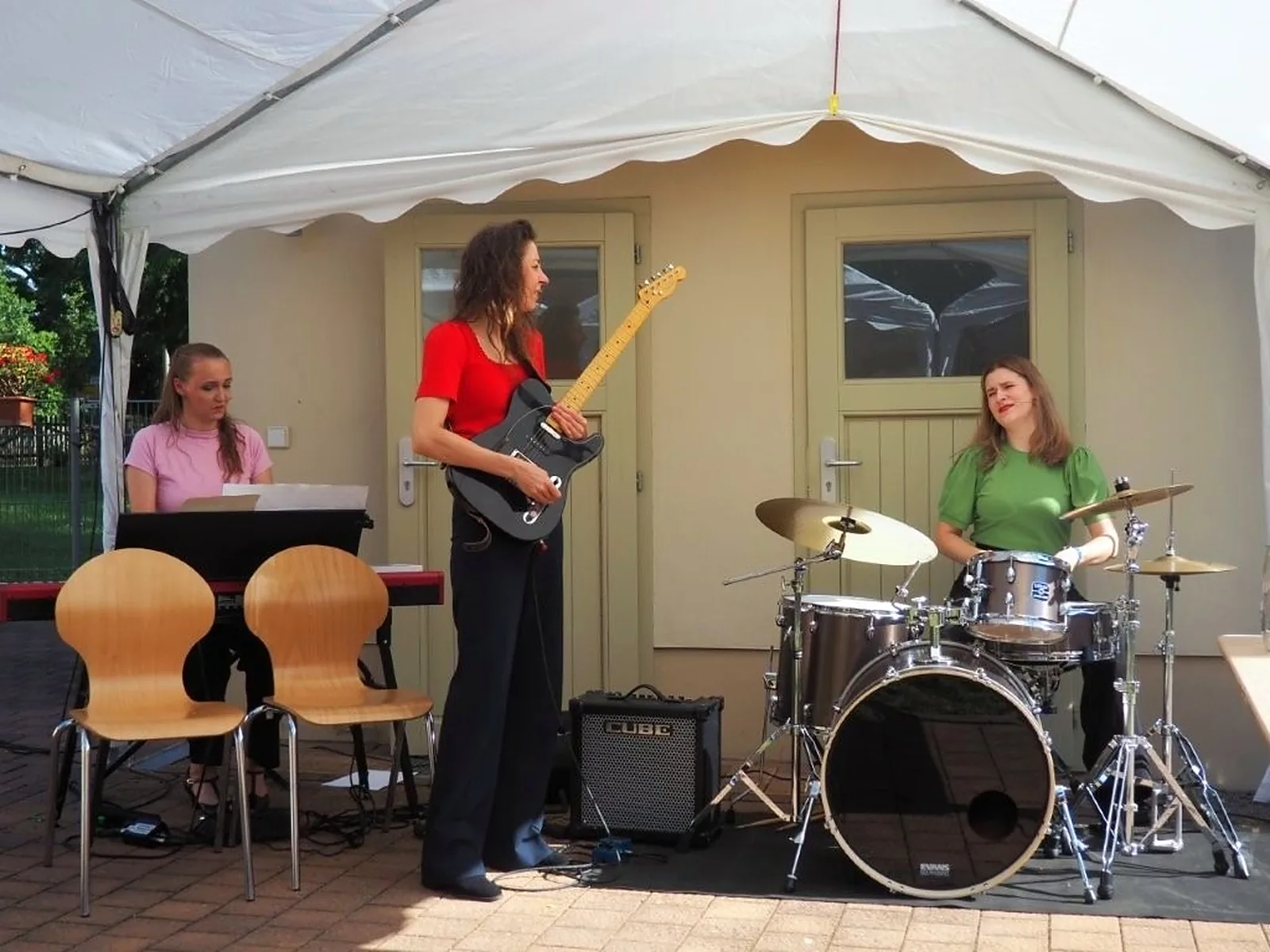 Band mit Gitarre, Schlagzeug und Keyboard spielt im Zelt vor dem Bürgerhaus
