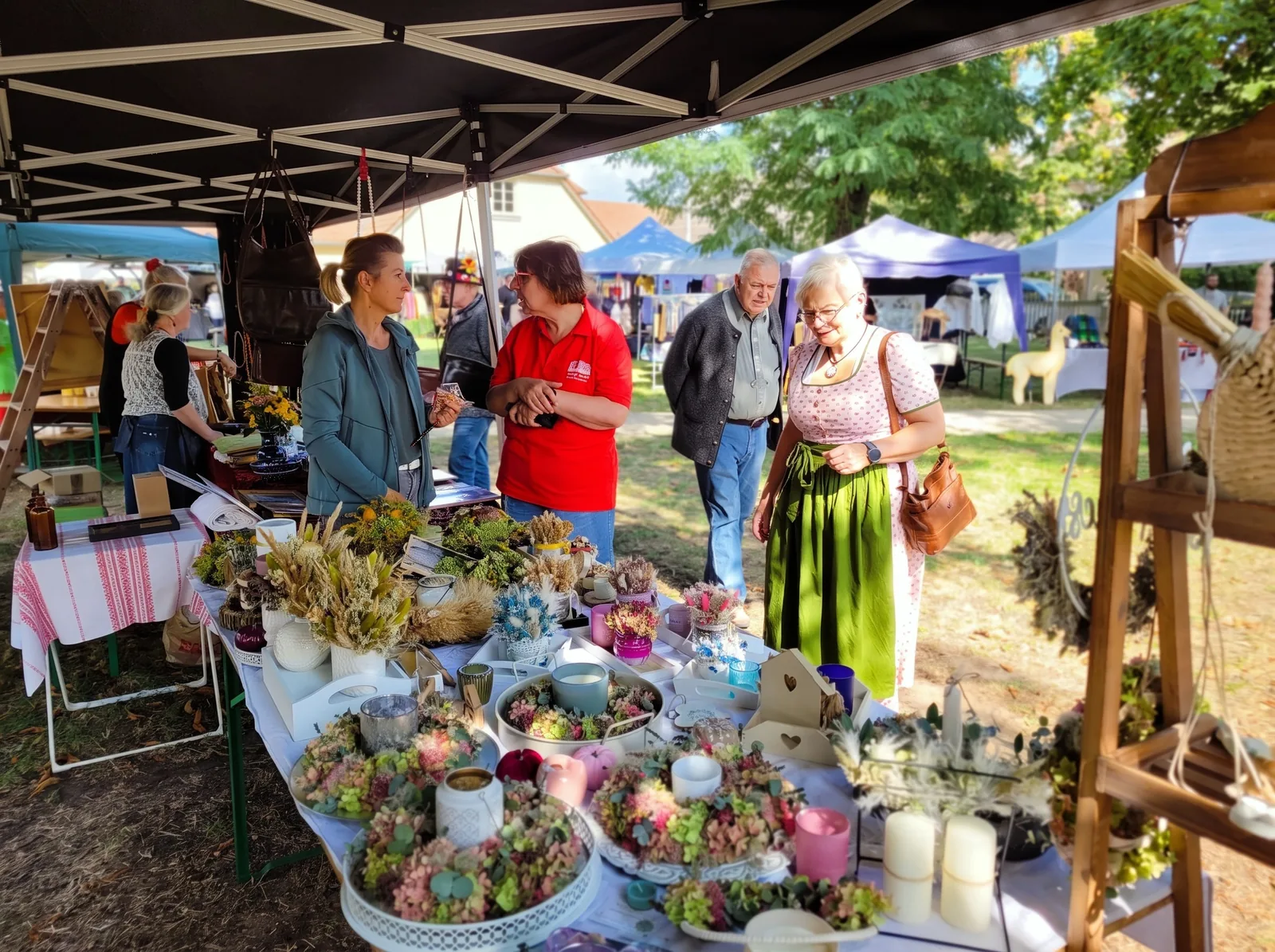 Stand mit Trockenblumen und Kerzen beim Schäferfest, Besucher im Gespräch