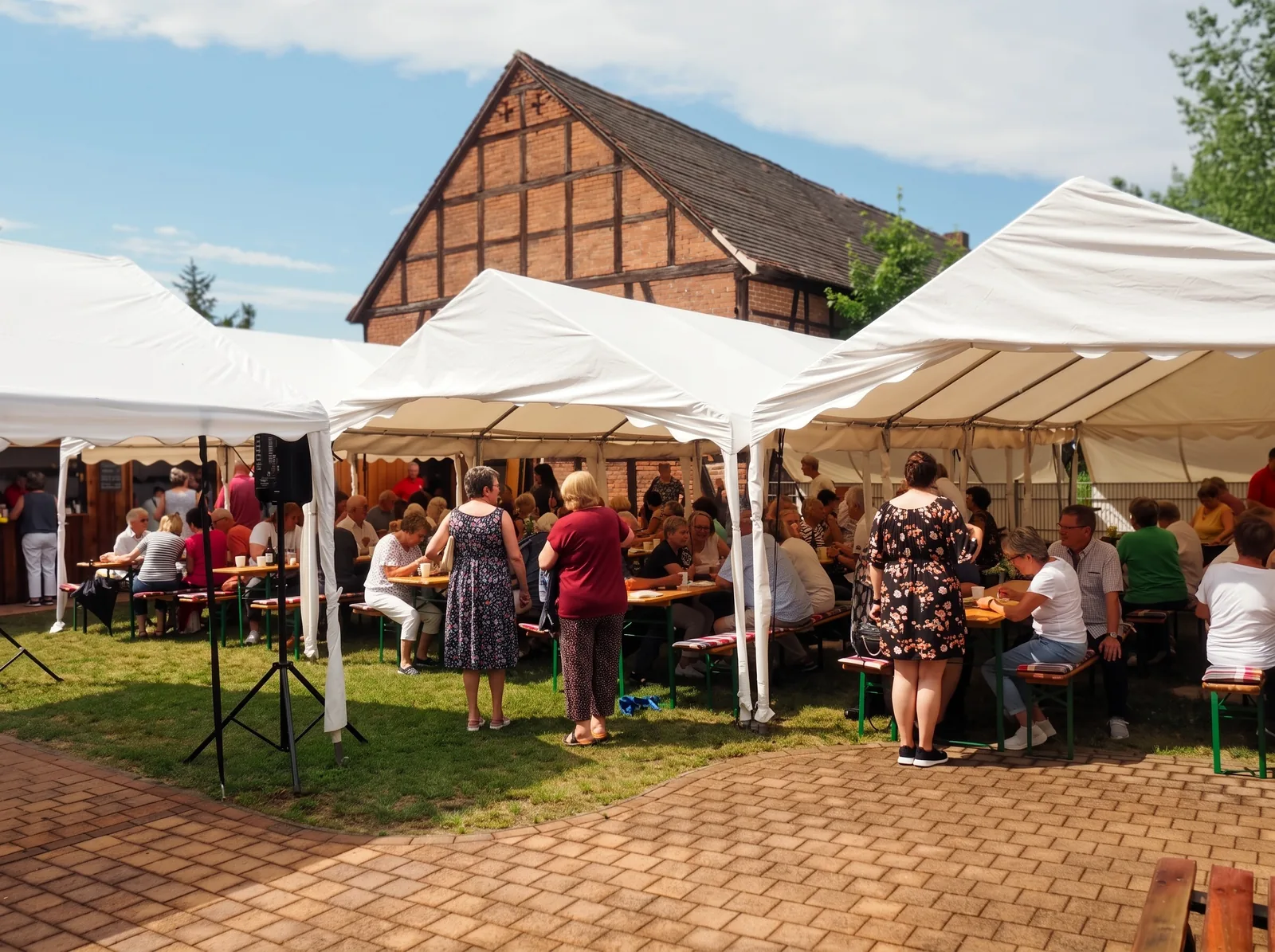 Festzelte und voll besetzte Bierbänke beim Fest des Bürgervereins, dahinter die alte Fachwerkscheune