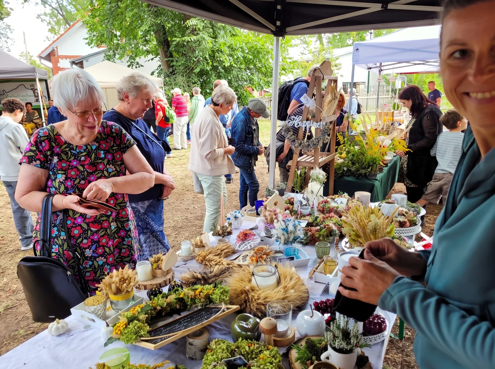 Besucherinnen stöbern am Marktstand mit Herbstdekoration beim Schäferfest